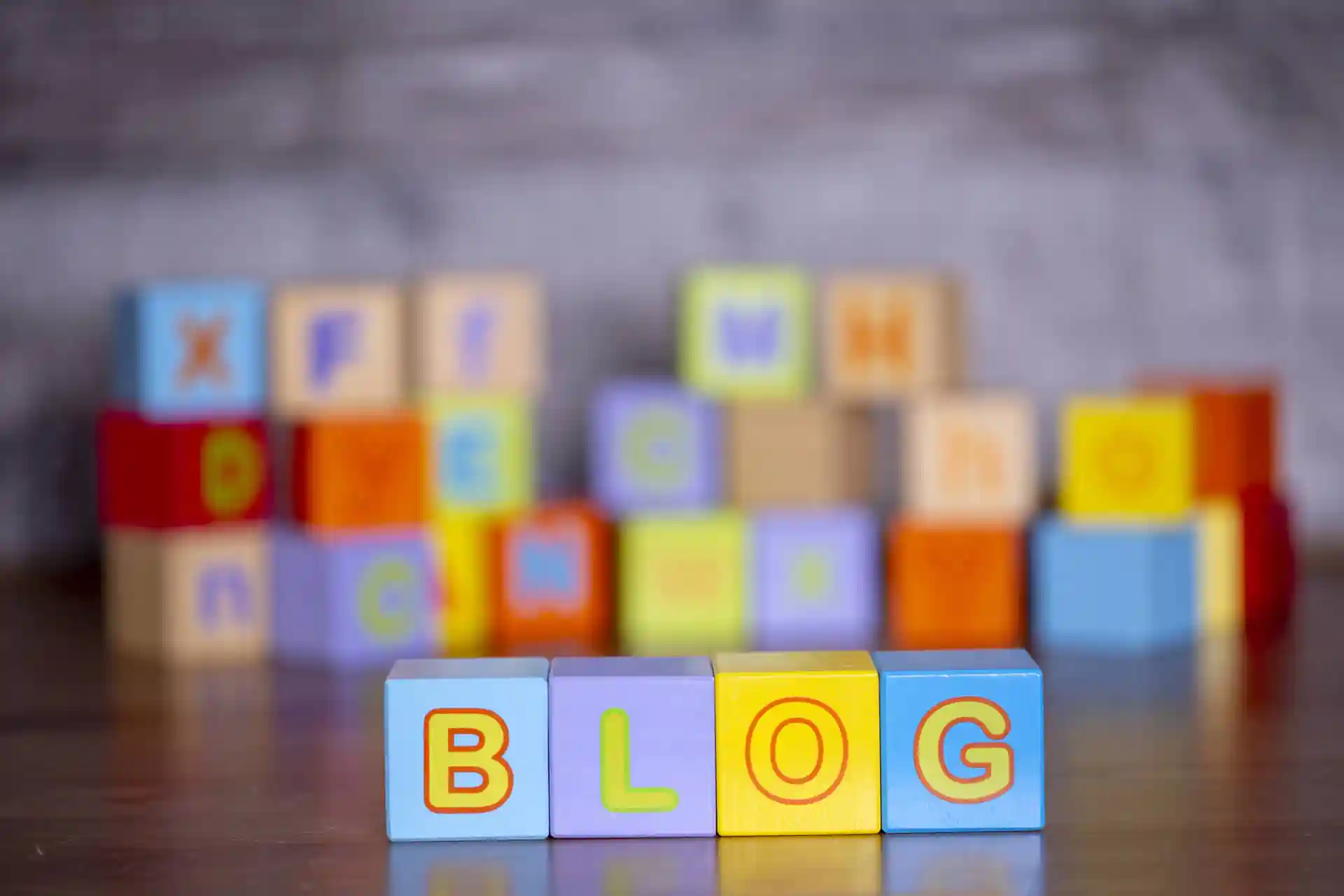 Scritta blog in cubetti di legno su sfondo sfocato.