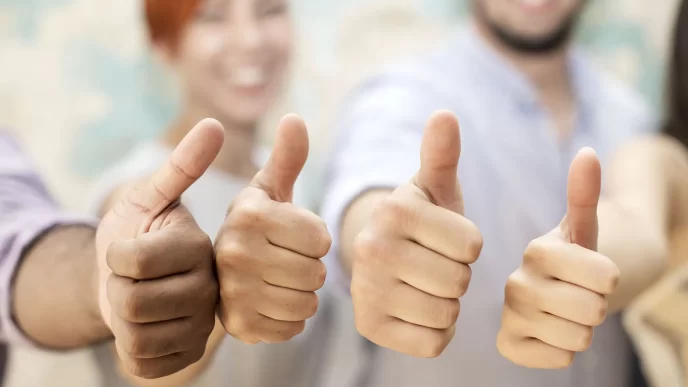 Gruppo di persone che mostrano il pollice in su, sorridendo e approvando.