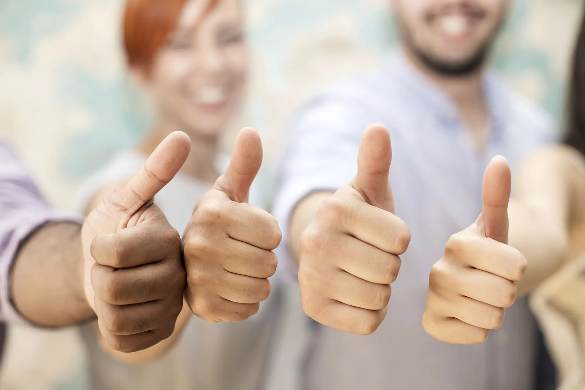 Gruppo di persone che mostrano il pollice in su, sorridendo e approvando.