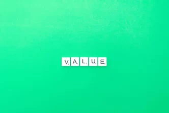 Parola 'VALUE' formata da lettere Scrabble su sfondo verde.