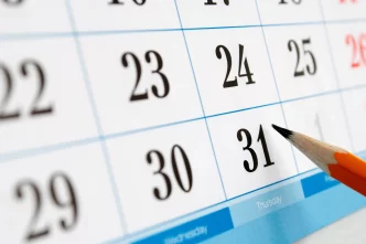 Primo piano di un calendario con una matita che indica la data del 31.