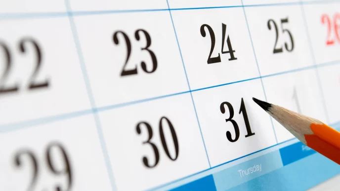 Primo piano di un calendario con una matita che indica la data del 31.