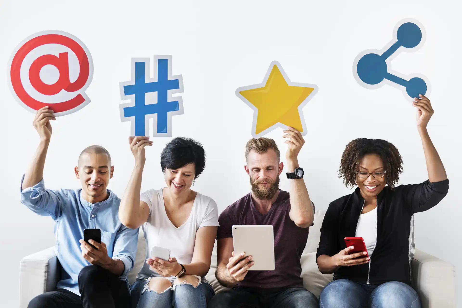 Persone che tengono simboli di social media come chiocciola, hashtag, stella e condivisione.