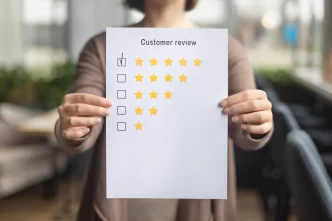 Persona che tiene un foglio con una recensione a 5 stelle.