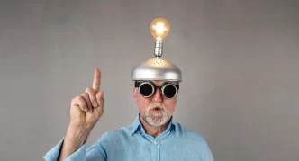 Uomo con occhiali strani e lampadina accesa sulla testa.