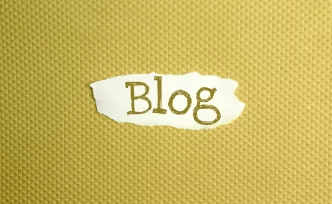 Immagine di carta strappata con la scritta 'Blog' su sfondo a motivo geometrico dorato