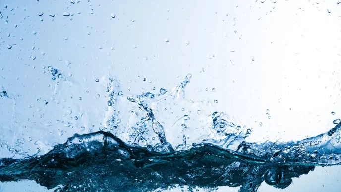 Gocce di acqua, spruzzi e schizzi su sfondo azzurro chiaro