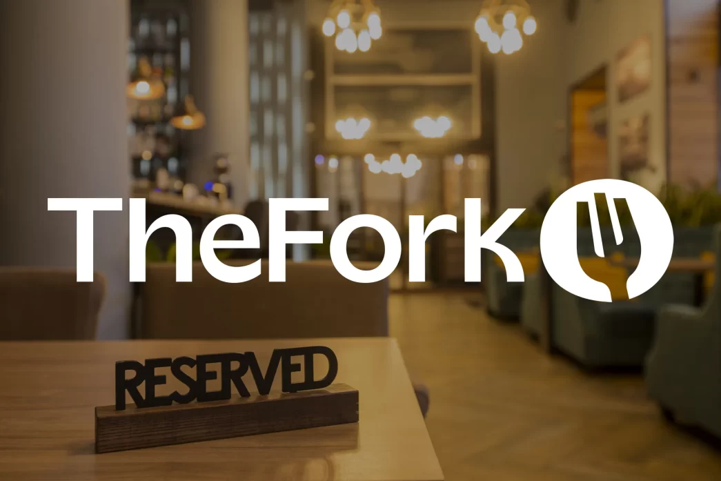 Logo di TheFork su sfondo di ristorante con tavolo riservato, illuminazione calda e atmosfera accogliente.