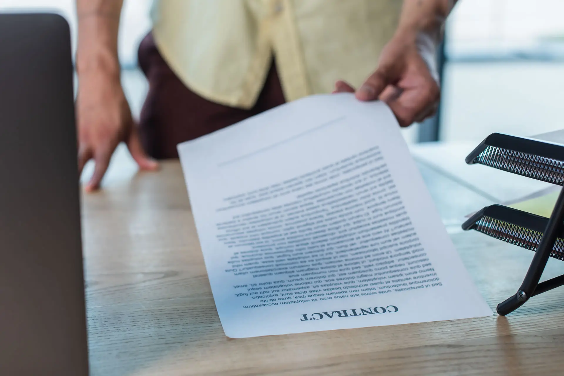 Vista ravvicinata di un uomo d'affari sfocato che prende un contratto da una scrivania.