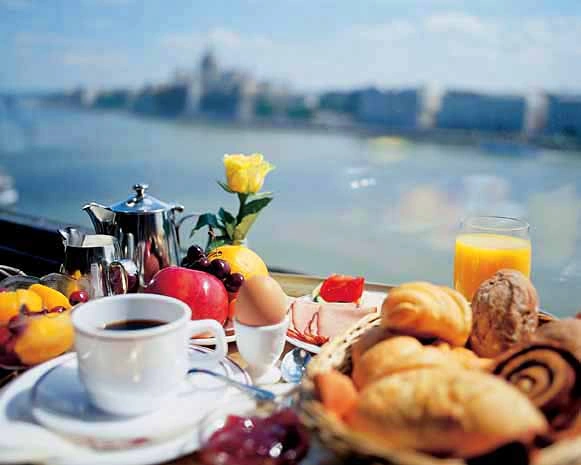 Colazione continentale con vista sul lago, con caffè, succo d'arancia, frutta fresca, pane e pasticceria.