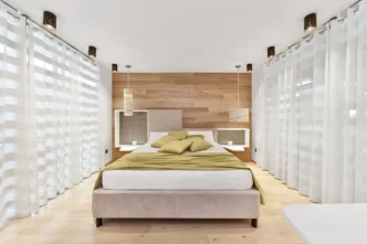 Camera d'albergo moderna con letto matrimoniale e ampie finestre.