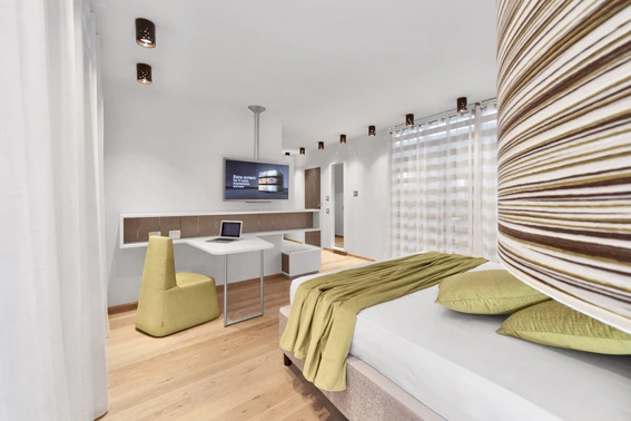 Camera d'albergo con letto matrimoniale e scrivania.