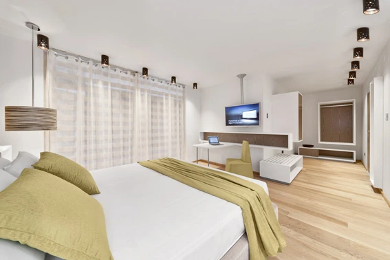 Camera d'albergo spaziosa con letto matrimoniale e TV a parete.