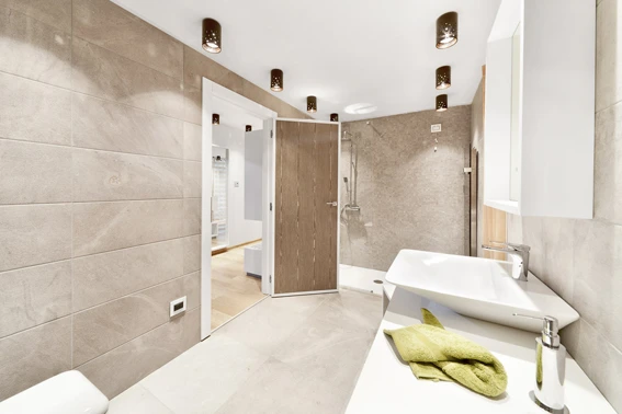 Bagno d'albergo con doccia, lavabo e arredi moderni.
