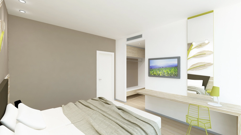 Vista della camera d'hotel con letto matrimoniale, scrivania, sedia moderna e televisore a schermo piatto.