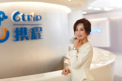 Donna sorridente in un ufficio di Ctrip International, con il logo dell'azienda visibile sullo sfondo.